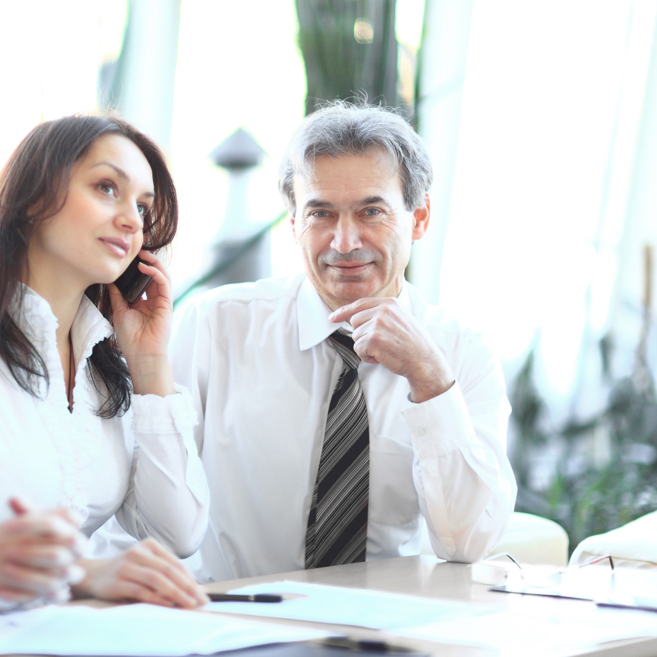Financial advisors reviewing documents with a client in a modern office